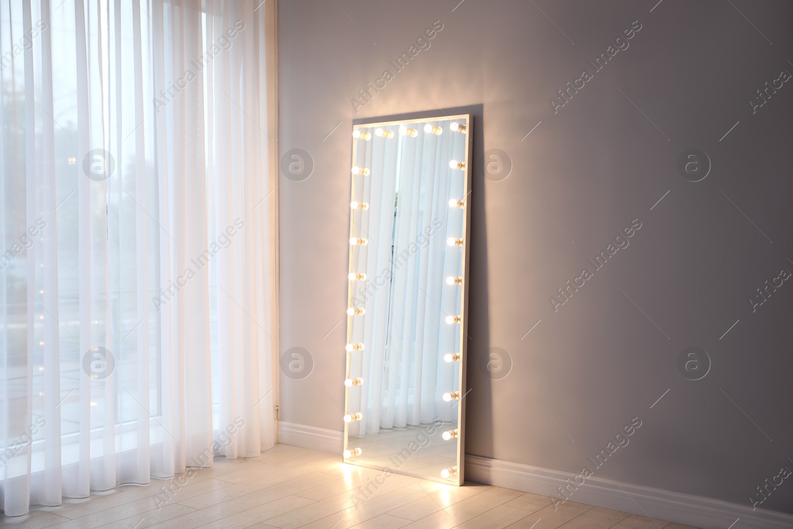 Image of Full length dressing mirror with lamps in stylish room interior