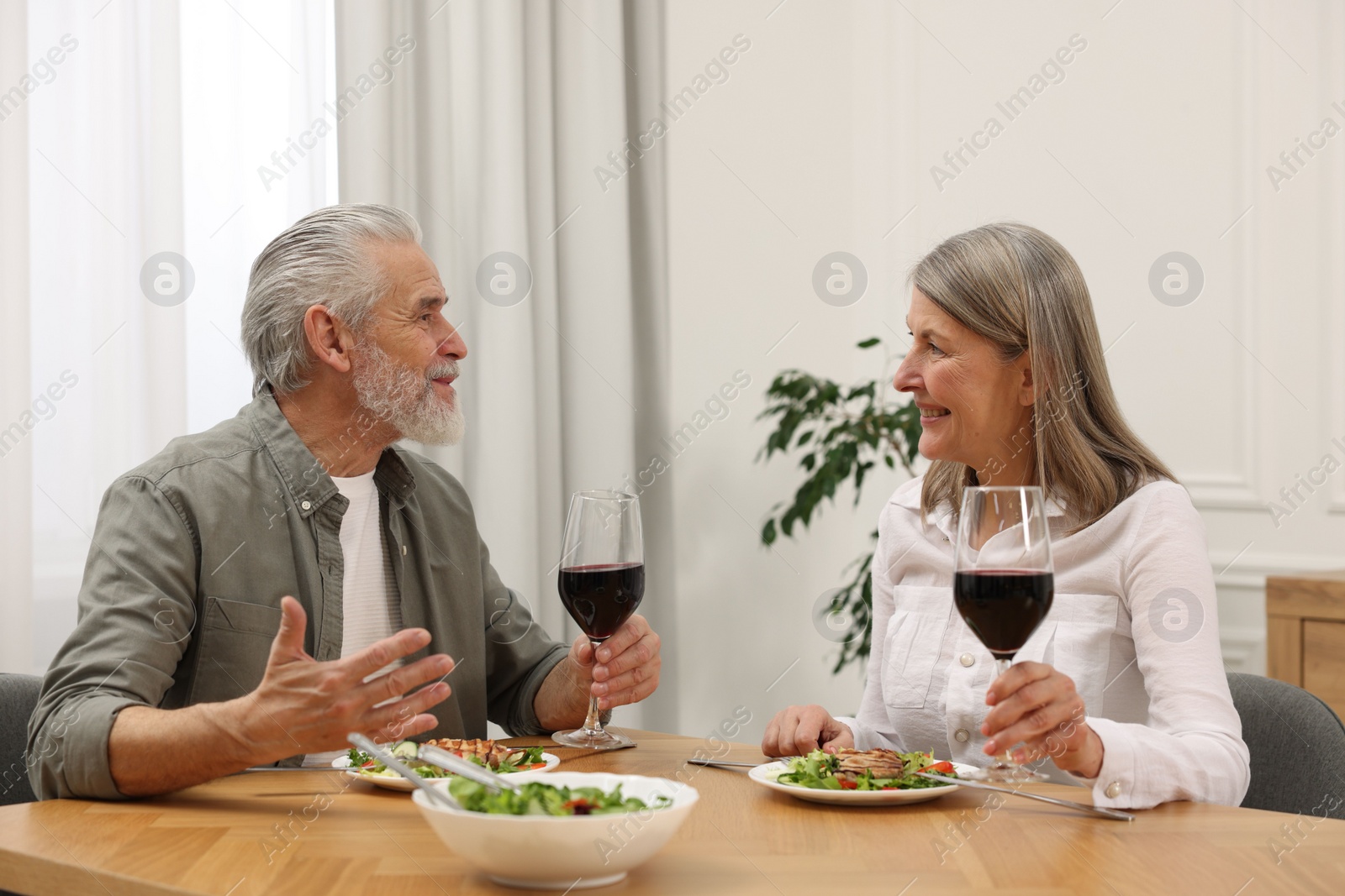 Photo of Happy senior couple having romantic dinner at home