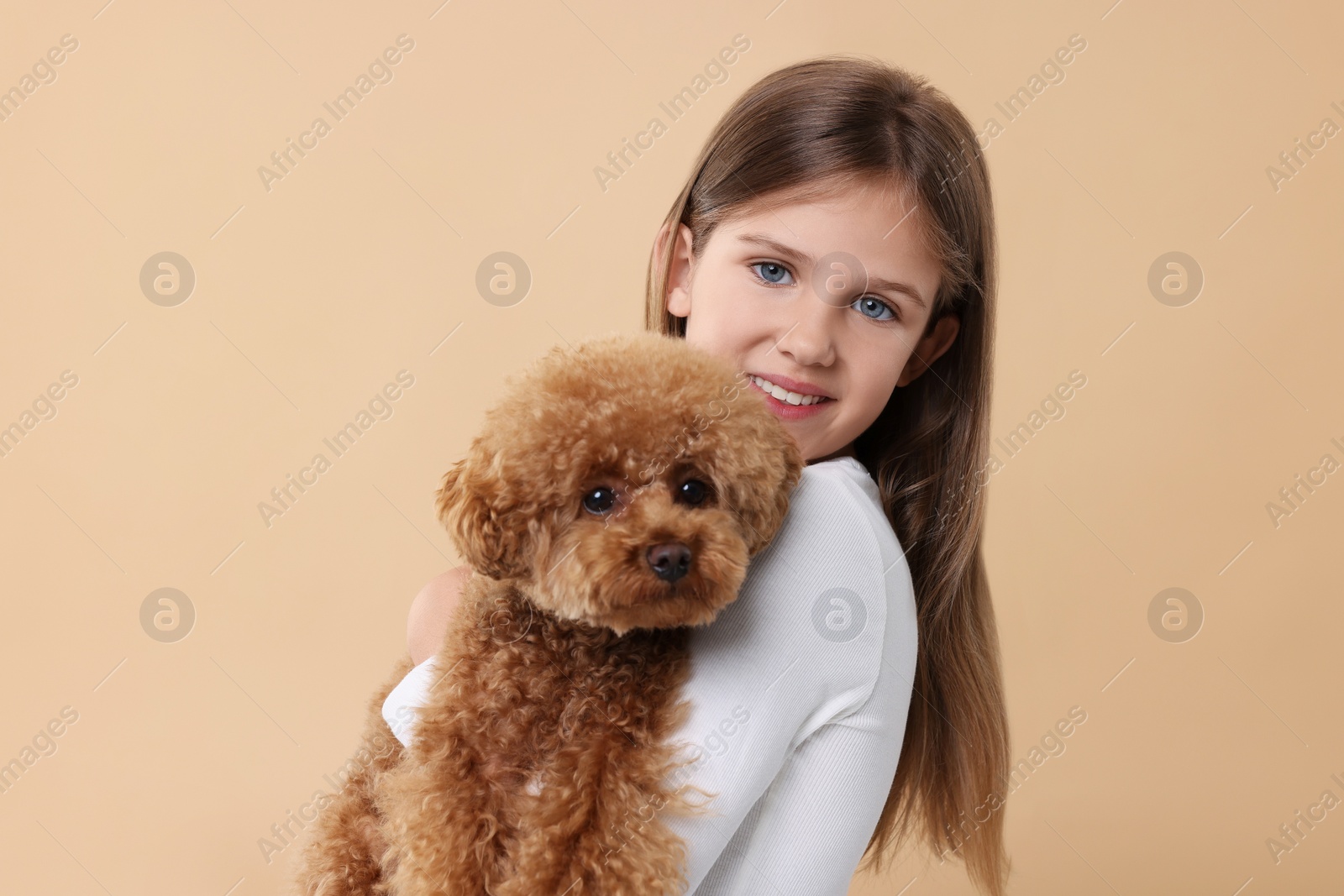 Photo of Little child with cute puppy on beige background. Lovely pet