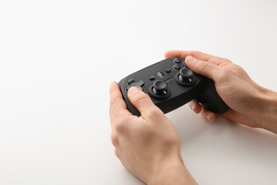 Photo of Young man holding video game controller on white background, closeup