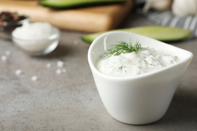 Photo of Cucumber sauce in ceramic bowl on table, space for text. Traditional Tzatziki