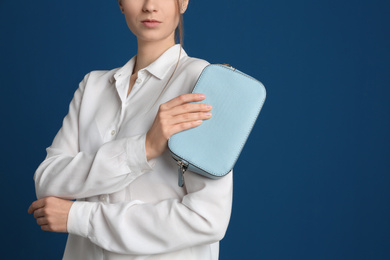 Photo of Young woman with stylish bag on blue background, closeup. Space for text