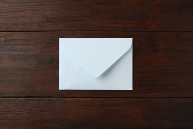 Photo of White paper envelope on wooden table, top view