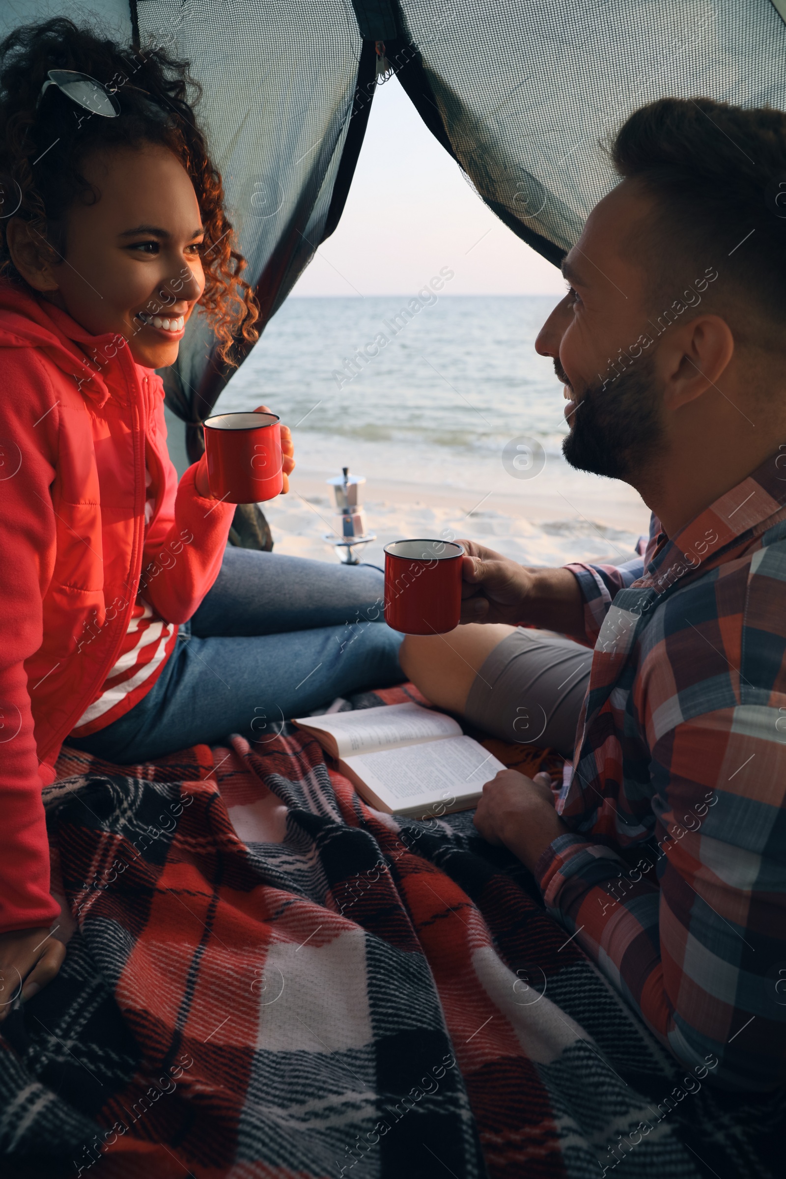 Photo of Couple resting in camping tent near sea