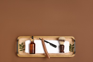Photo of Set of men's shaving tools on brown background, top view. Space for text