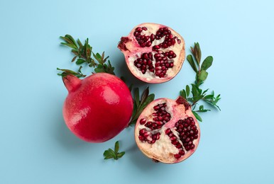 Flat lay composition with ripe pomegranates on light blue background