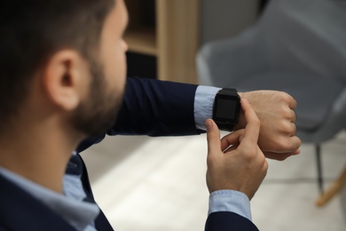 Photo of Businessman with smart watch in office, closeup