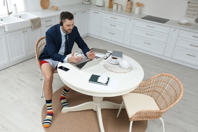 Photo of Businessman in underwear pretending to wear formal clothes during video call at home