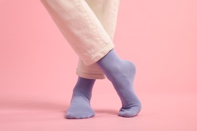 Woman in stylish purple socks and pants on pink background, closeup
