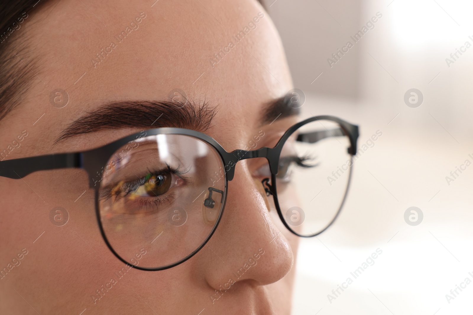 Photo of Woman wearing glasses on blurred background, closeup