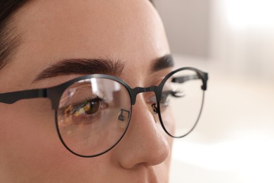 Photo of Woman wearing glasses on blurred background, closeup