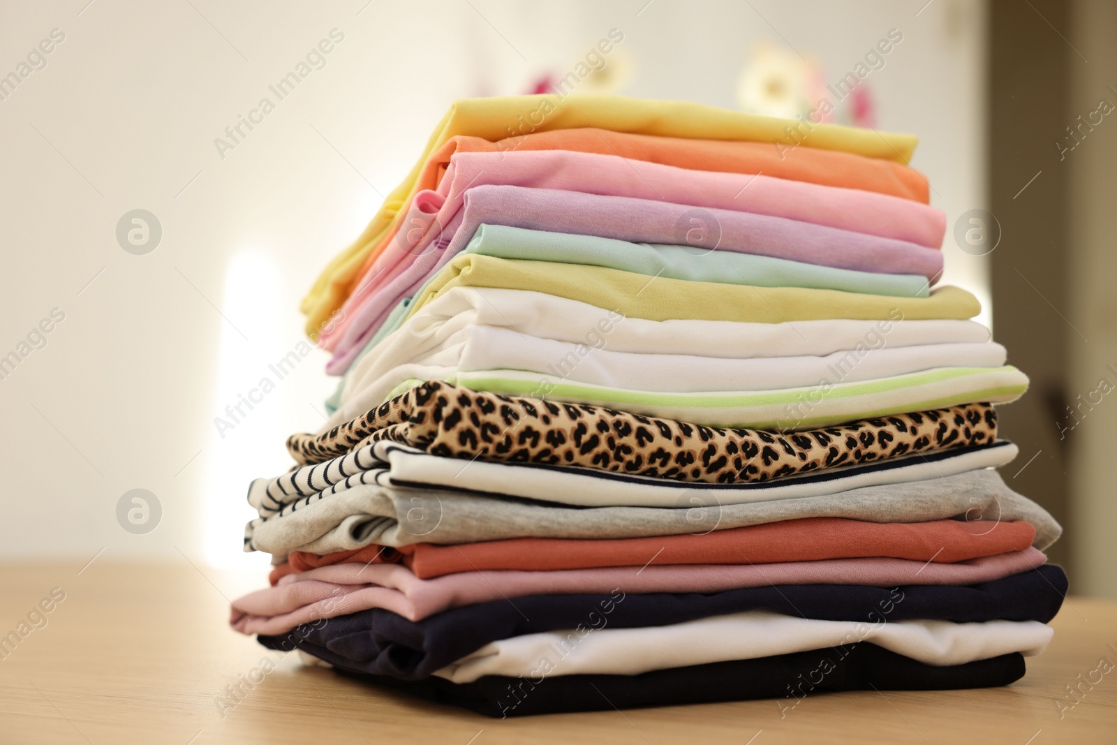 Photo of Stack of clean clothes on wooden table