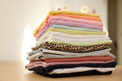 Photo of Stack of clean clothes on wooden table