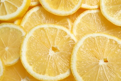 Photo of Many fresh juicy lemon slices as background, top view