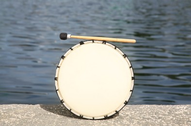 Drum and drumstick near sea. Percussion musical instrument