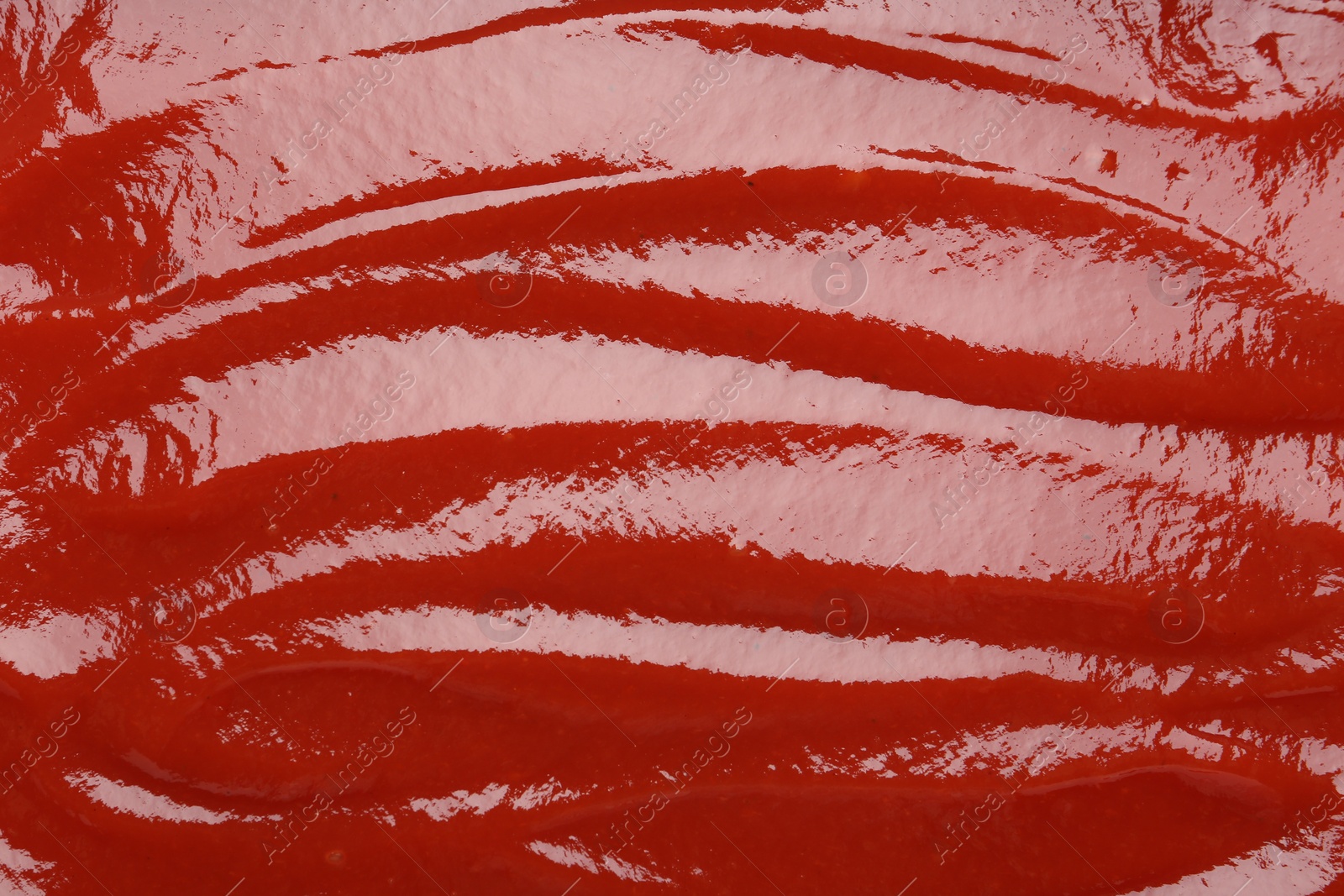 Photo of Tasty ketchup as background, top view. Tomato sauce