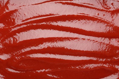 Photo of Tasty ketchup as background, top view. Tomato sauce