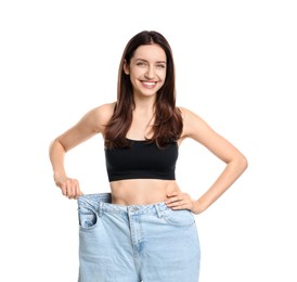 Photo of Happy young woman in big jeans showing her slim body on white background