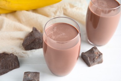 Fresh yummy chocolate milk on white wooden table, closeup