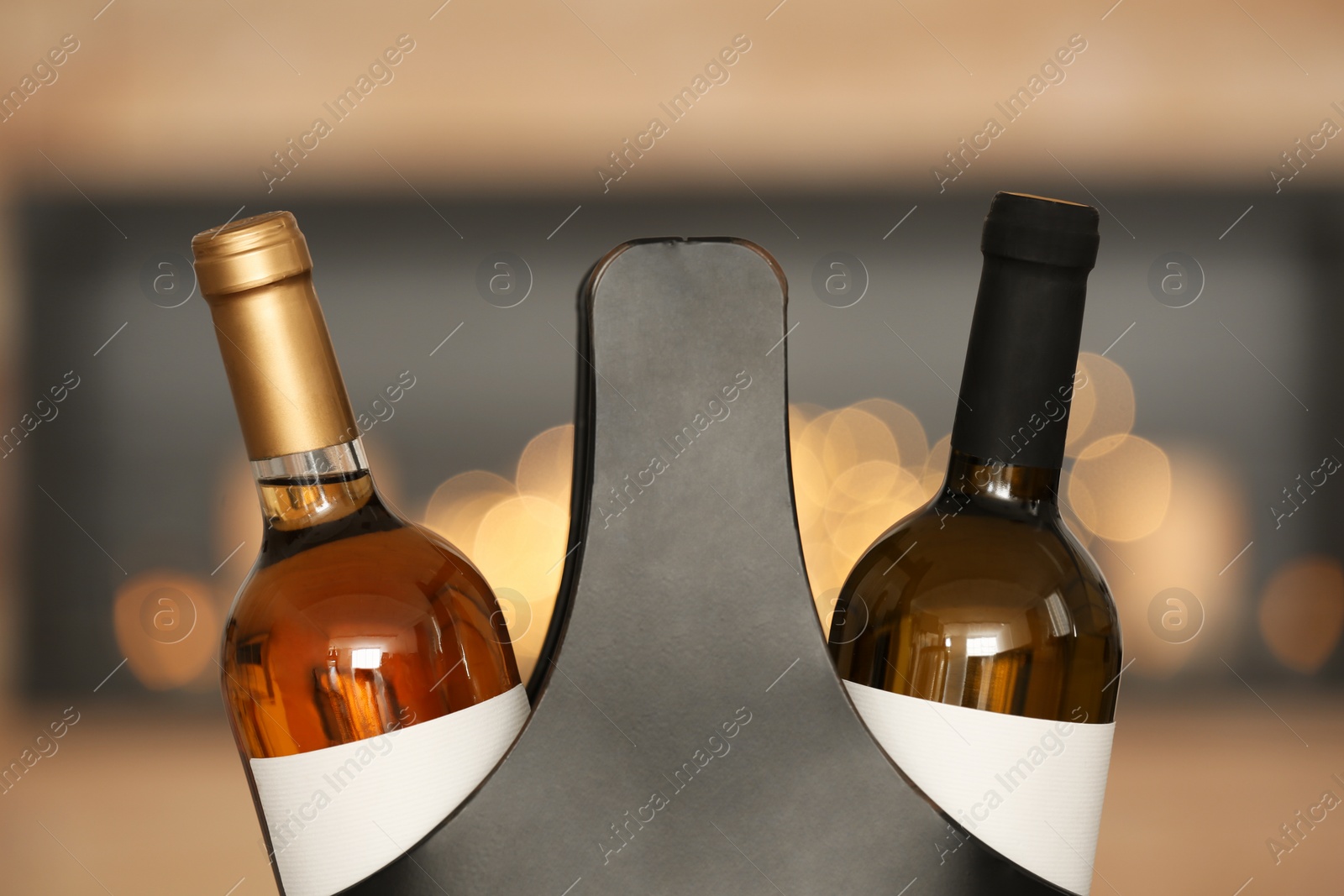 Photo of Festive package with bottles of wine against blurred background, closeup