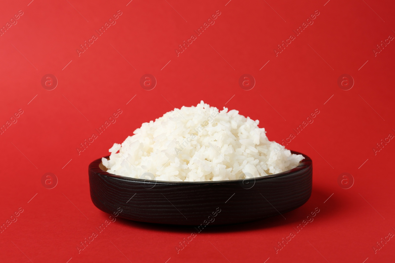 Photo of Bowl of boiled rice on color background