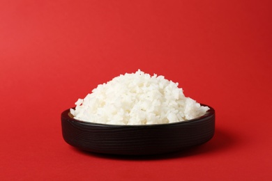 Photo of Bowl of boiled rice on color background