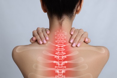 Image of Woman suffering from pain in neck on light grey background, closeup