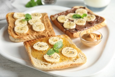 Photo of Tasty toasts with banana, honey and chia seeds on plate
