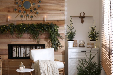 Photo of Beautiful room decorated for Christmas with potted firs. Interior design