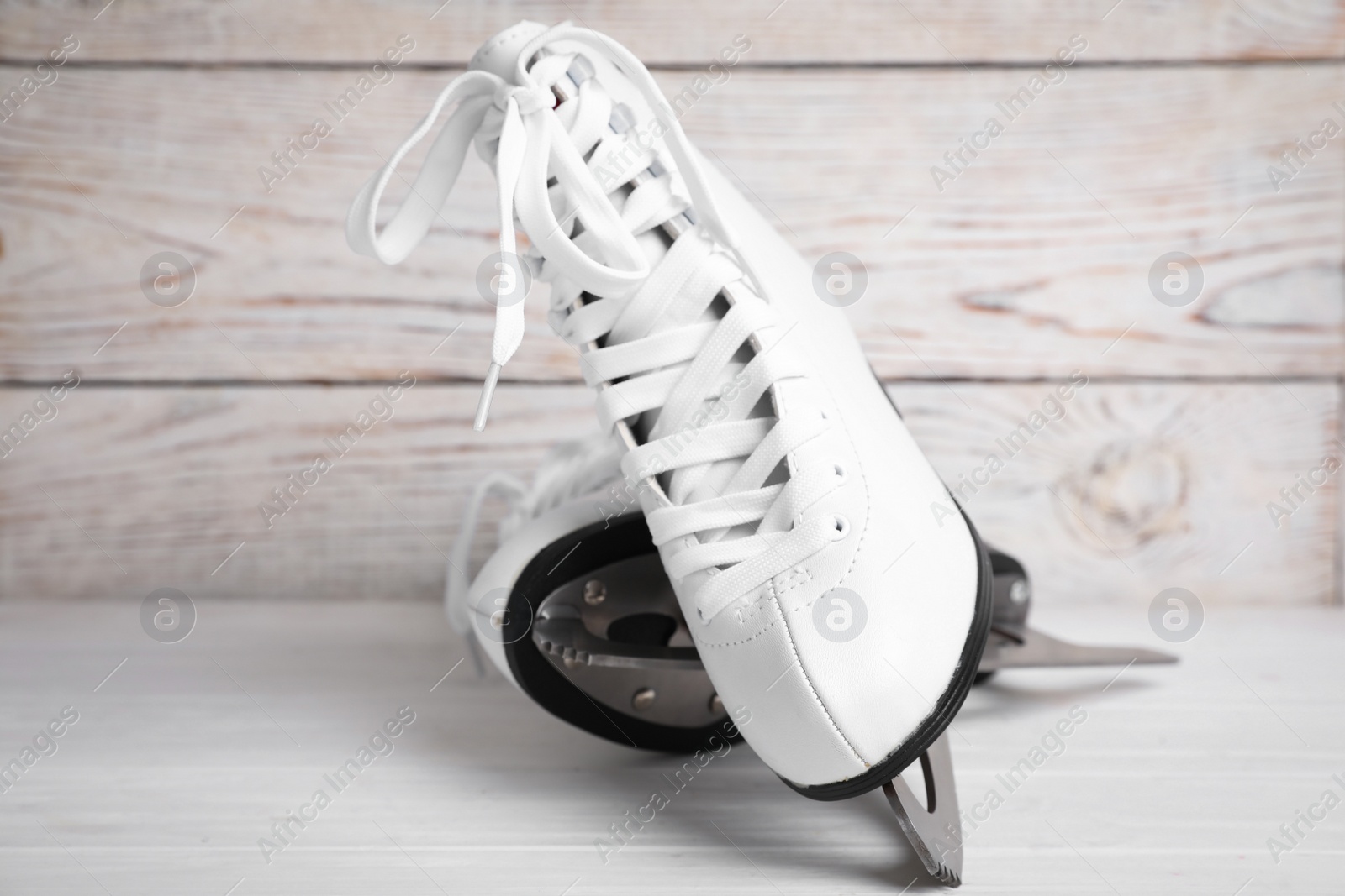 Photo of Pair of ice skates on white wooden table, closeup