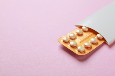 Photo of Birth control pills on pink background. Space for text