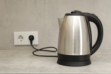 Photo of Modern electric kettle on counter in kitchen. Space for text