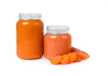 Jars of healthy baby food and carrot slices on white background