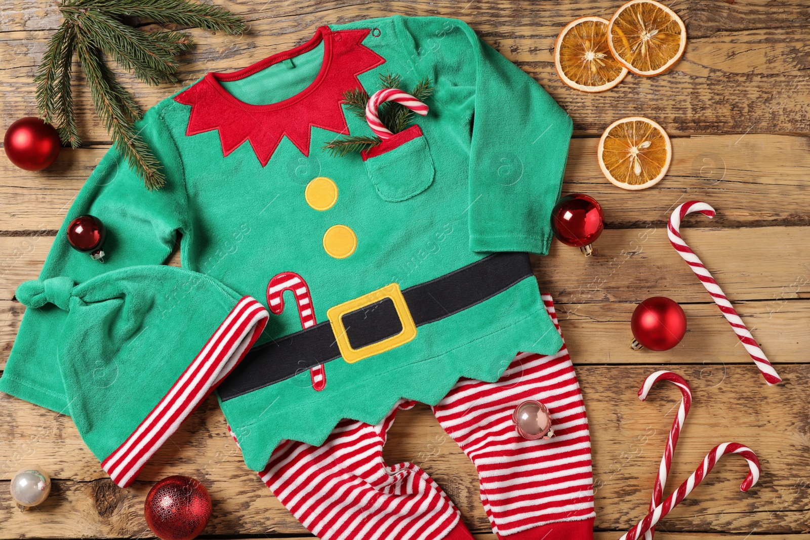 Photo of Flat lay composition with cute Christmas baby clothes on wooden background