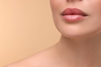Photo of Woman with beautiful lips on beige background, closeup. Space for text