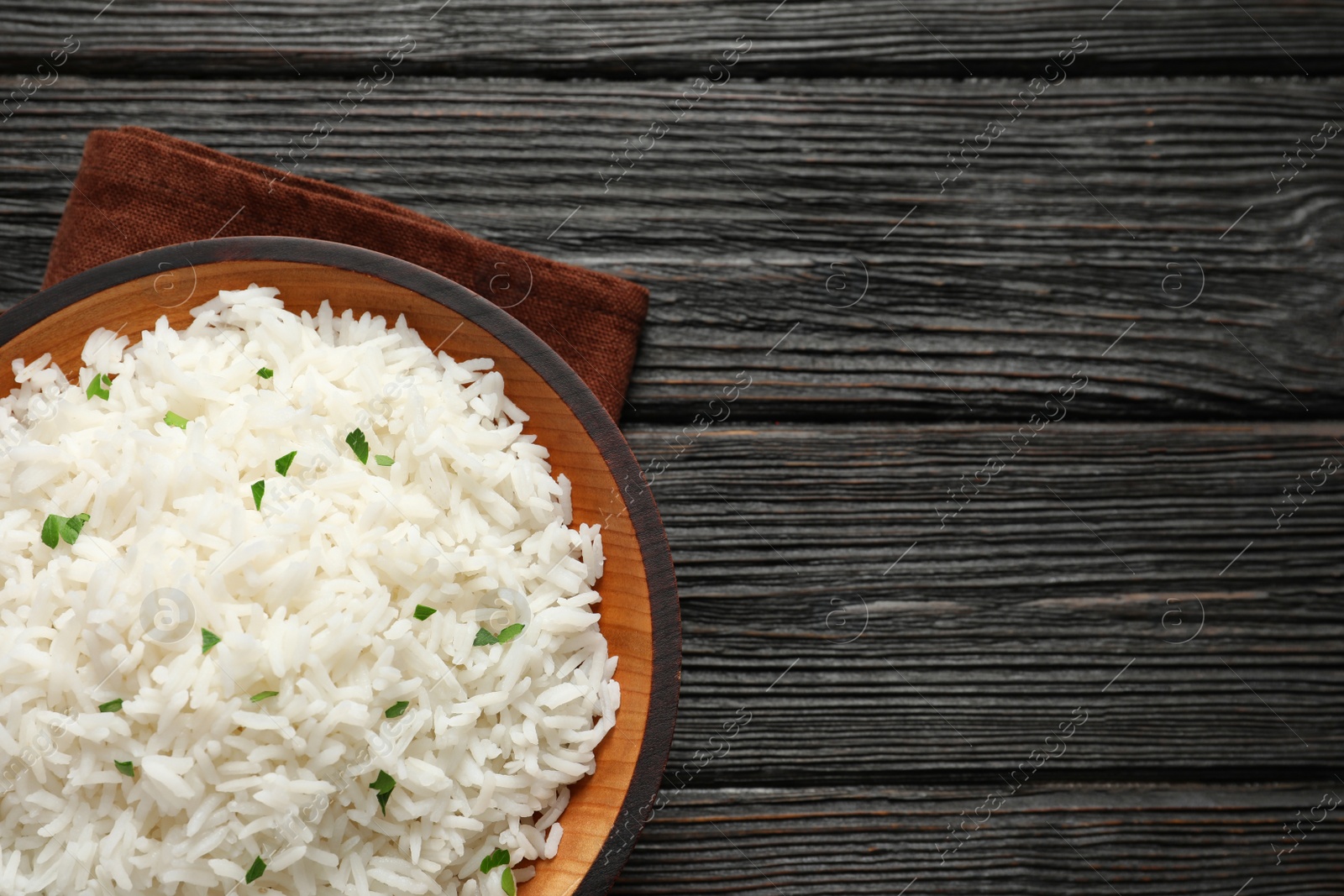 Photo of Plate of tasty cooked rice on wooden background, top view. Space for text