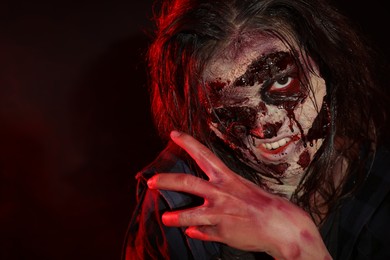 Photo of Scary zombie on dark background, closeup. Halloween monster