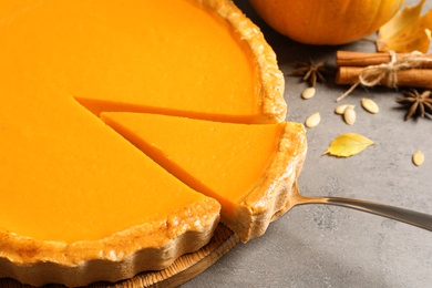 Photo of Fresh delicious homemade pumpkin pie on gray table, closeup