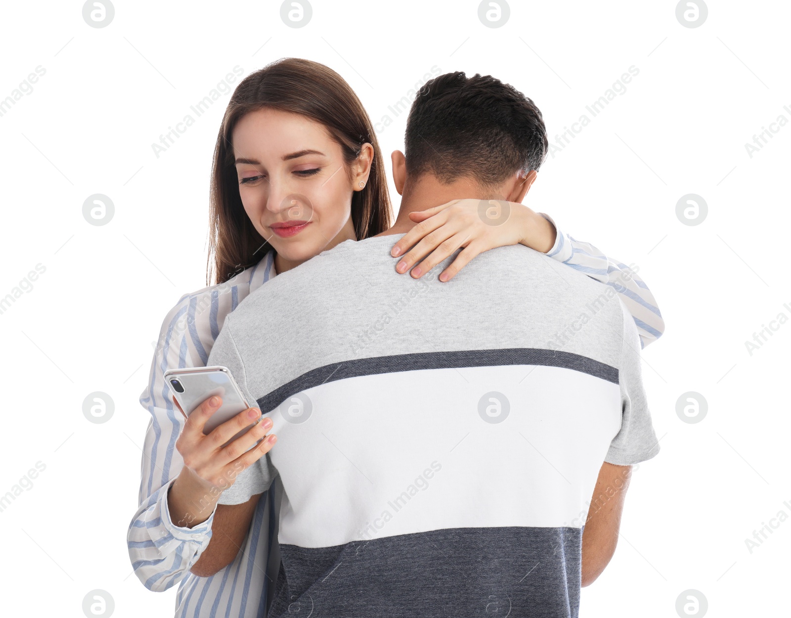 Photo of Woman interested in smartphone while hugging her boyfriend on white background. Relationship problems