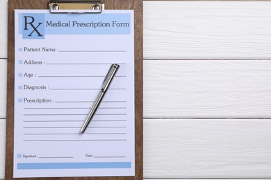 Photo of Medical prescription form with empty fields and pen on white wooden table, top view. Space for text