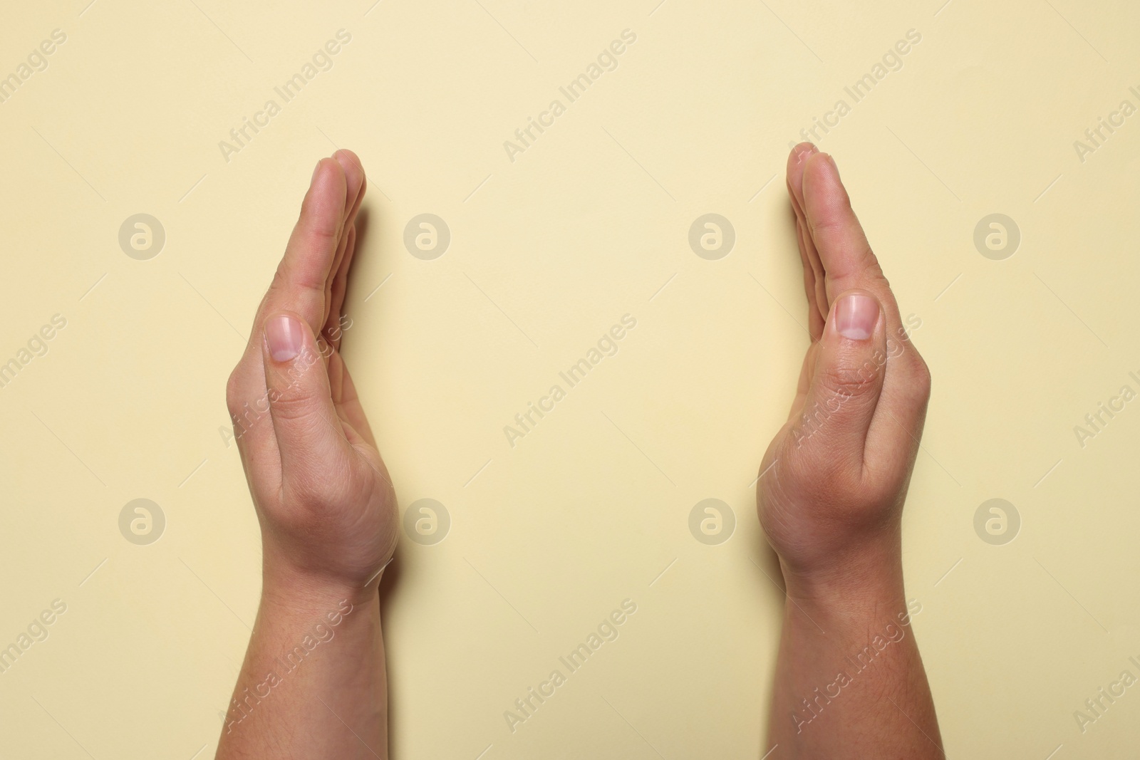 Photo of Woman holding on pale yellow background, closeup of hands. Space for text