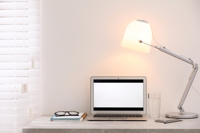 Photo of Modern workplace with laptop on table in office. Space for text