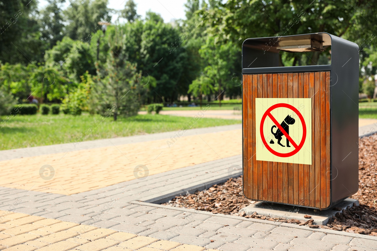 Image of Sign NO DOG WASTE PLEASE CLEAN IT UP on trash bin in park