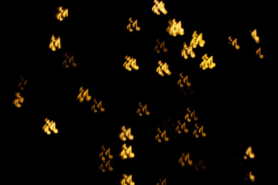 Photo of Blurred view of note shaped lights on black background. Bokeh effect