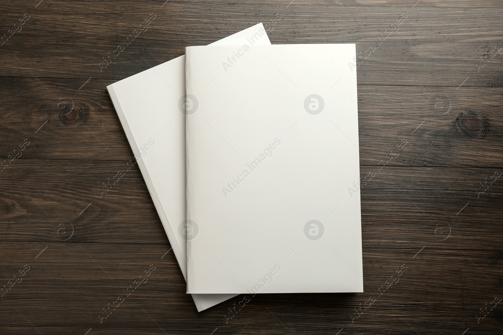 Photo of Blank paper brochures on wooden table, top view. Mockup for design