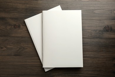 Blank paper brochures on wooden table, top view. Mockup for design