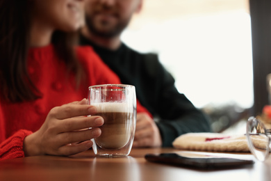 Photo of Lovely couple with fresh aromatic coffee at table in cafe, closeup
