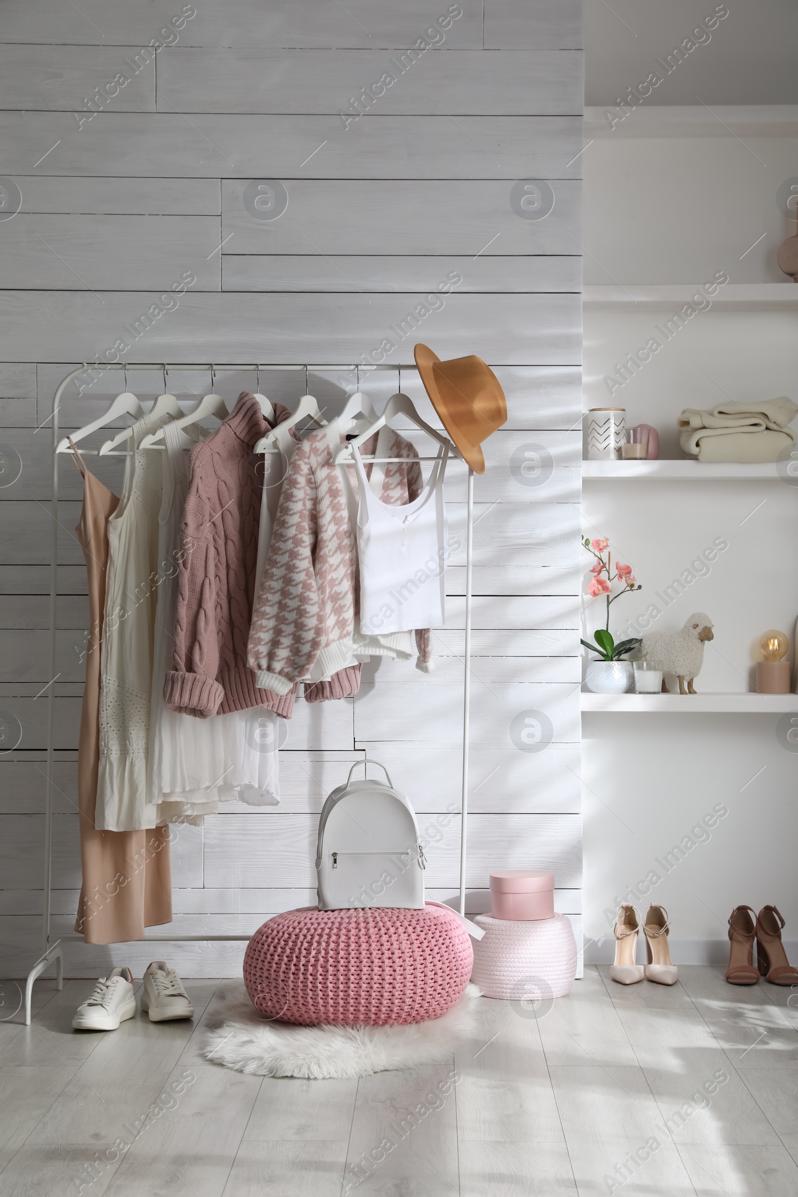 Photo of Rack with different stylish clothes, shoes and decorative elements in dressing room. Interior design