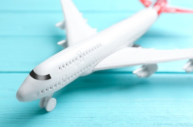 Toy airplane on light blue wooden background, closeup