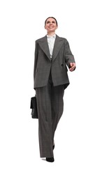 Beautiful businesswoman in suit with briefcase walking on white background, low angle view